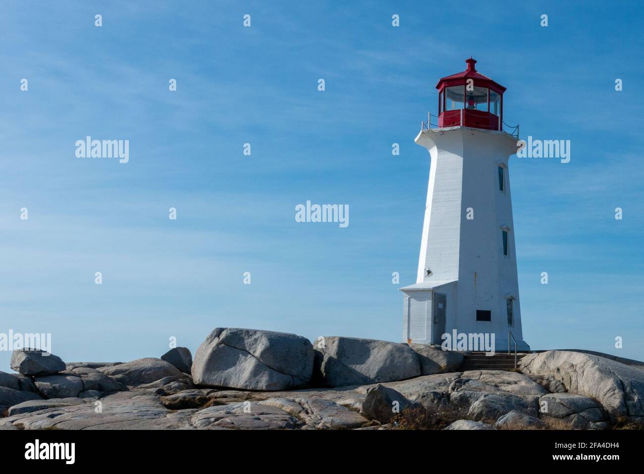 Leuchtturmturm aus weißem, sechseckigem, sich verjüngendem Beton. Die Struktur steht auf einem Felsen. Stockfoto