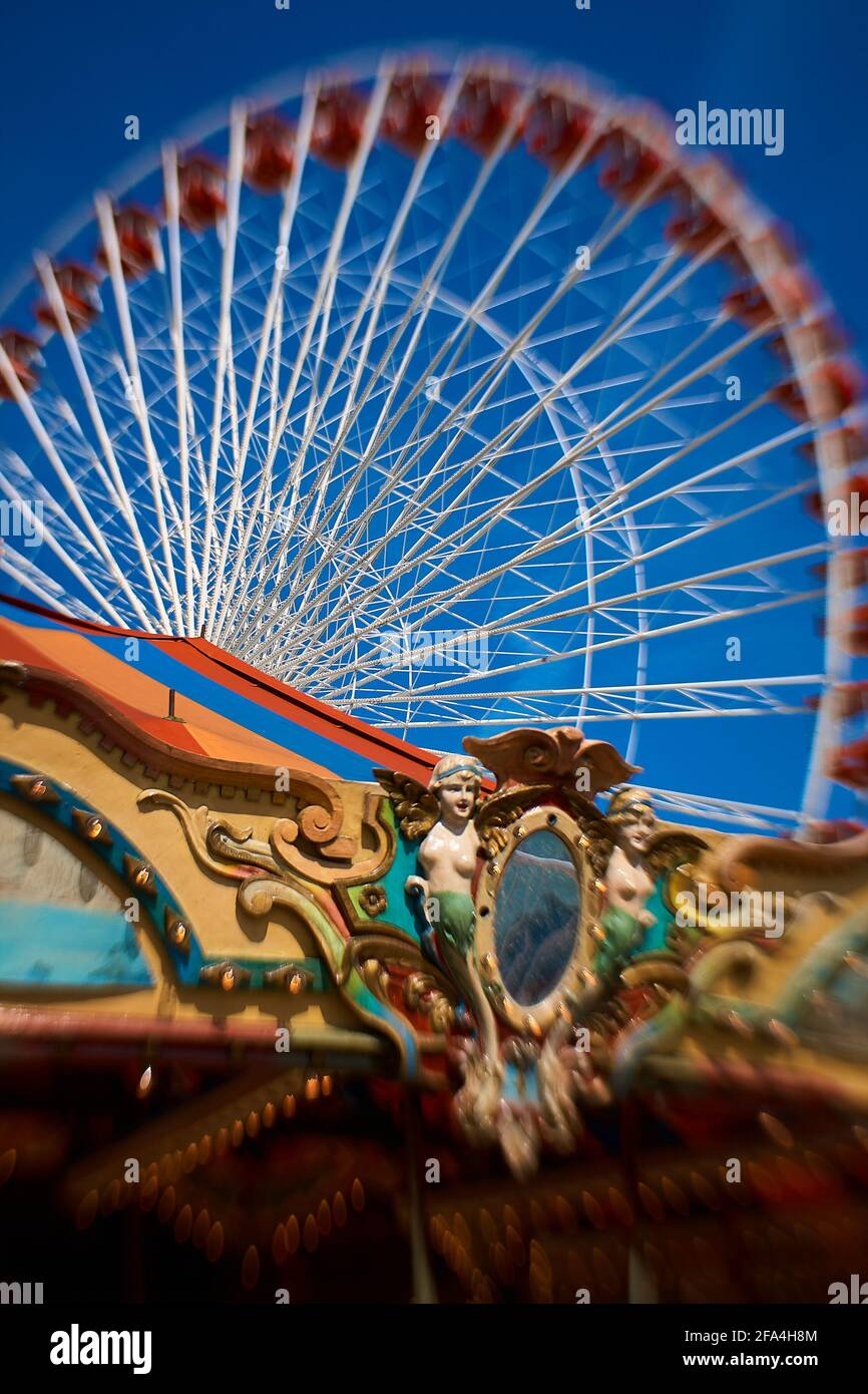Nahaufnahme eines Lensbaby-Fotos von der Oberseite des Karussells mit einem Riesenrad im Hintergrund am Navy Pier, Chicago Stockfoto