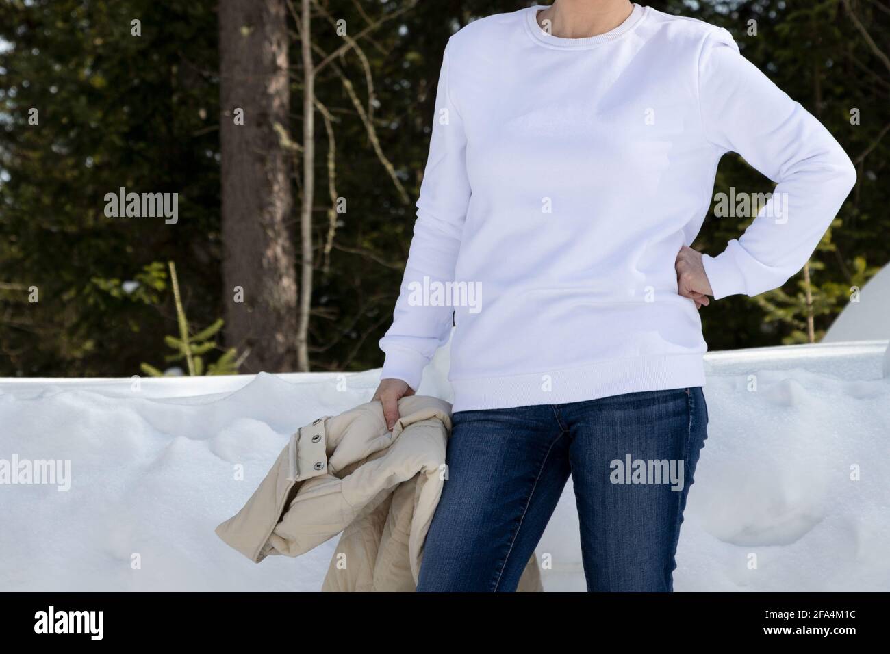 Weißes Fleece-Sweatshirt mit Rundhalsausschnitt, Mockup mit einem Mädchen in den winterverschneiten Wäldern. Schwere Sweatshirt Vorlage, Modell Mockup Stockfoto