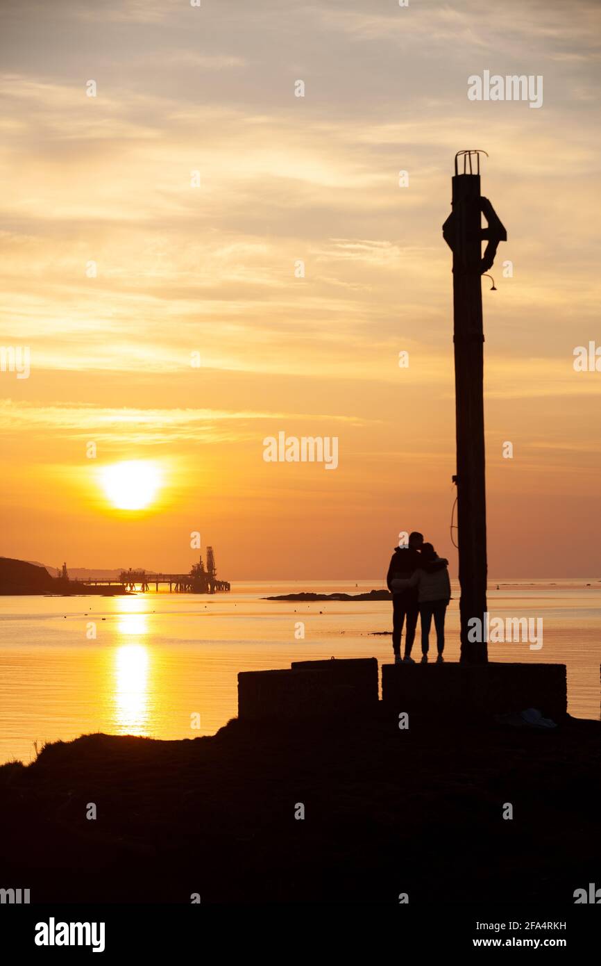 Dalgety Bay, Fife, Schottland. 23. April 2021. Ein junges Paar, das den Sonnenaufgang am Downing Point genießt. © Richard Newton / Alamy Live News Stockfoto