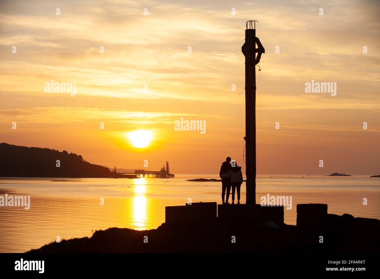 Dalgety Bay, Fife, Schottland. 23. April 2021. Ein junges Paar, das den Sonnenaufgang am Downing Point genießt. © Richard Newton / Alamy Live News Stockfoto