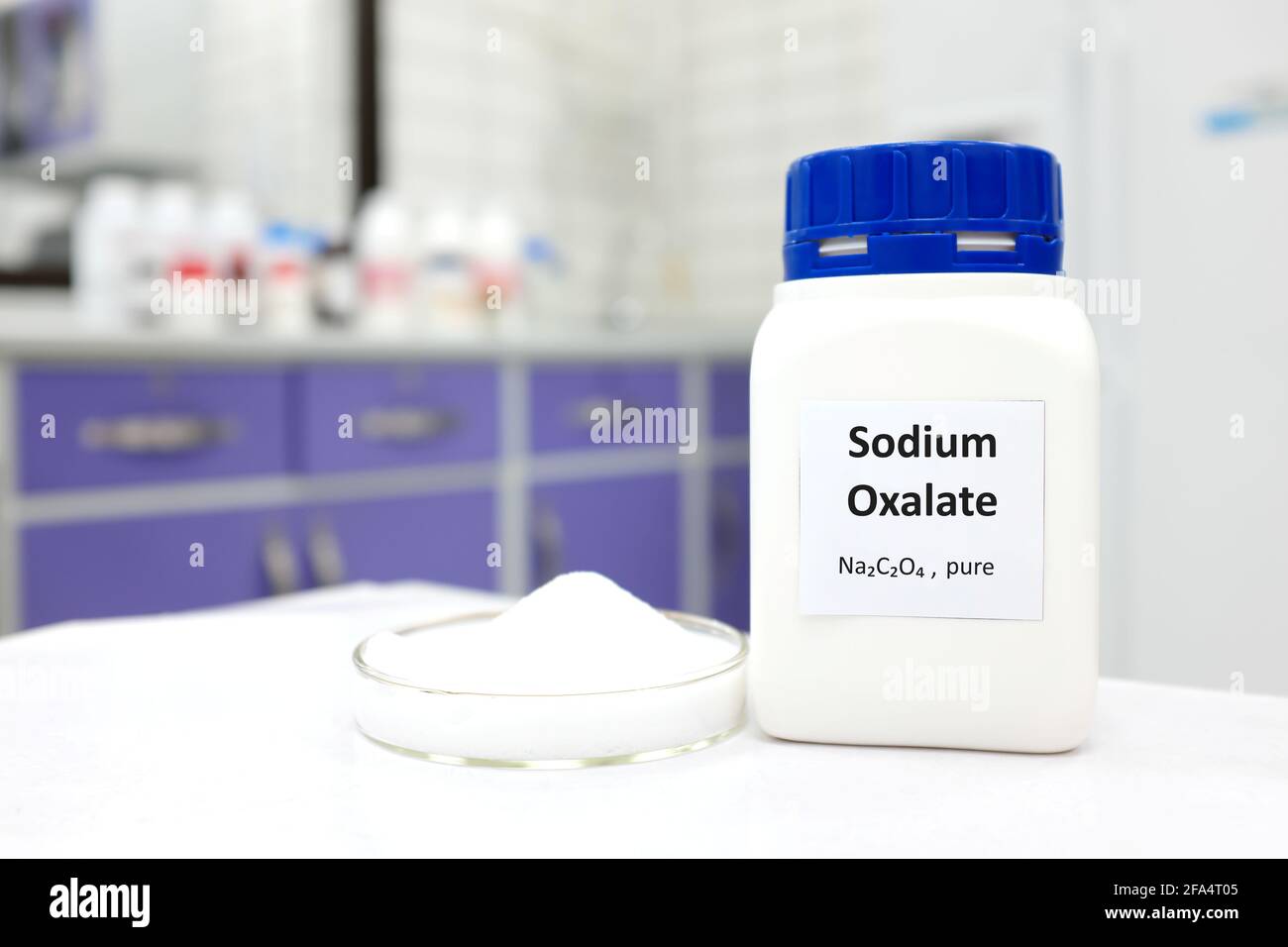 Selektiver Fokus der Flasche mit reinem Natriumoxalat toxische Chemikalie neben einer Petrischale mit weißer Festkristall-Pulversubstanz. Weißes Labor Stockfoto