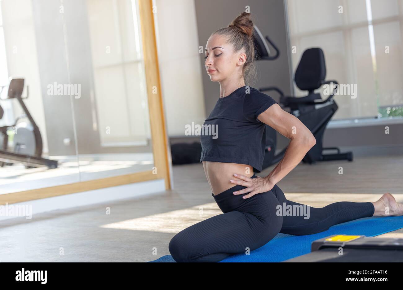 Schöne Fit Frau macht Yoga-Plank und beobachten Online-Tutorials Auf dem Laptop Übungen im Fitnessraum oder Fitnessraum gesunden Lebensstil Konzept Stockfoto