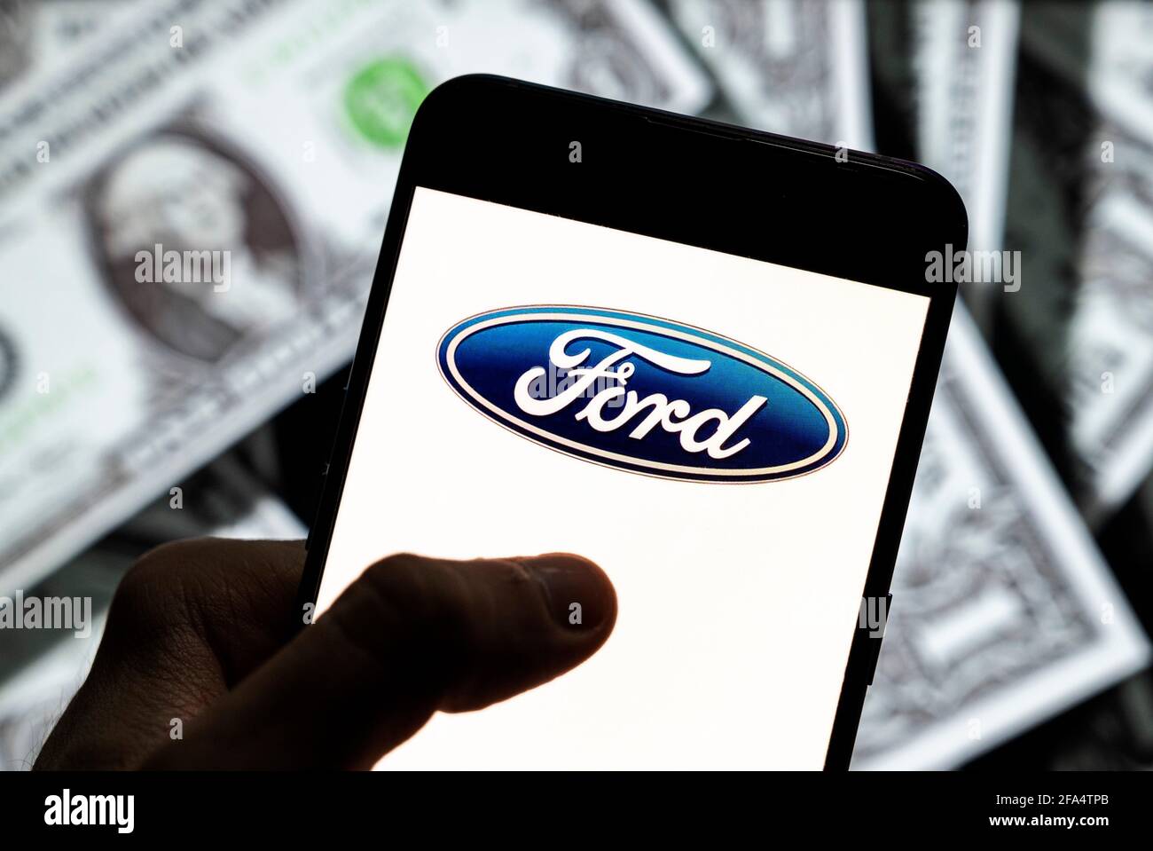 China. April 2021. In dieser Abbildung zeigt das US-amerikanische multinationale Automobilhersteller Ford-Logo auf einem Android-Bildschirm für mobile Geräte mit der Währung des US-Dollar-Symbols, das Symbol für den US-Dollar im Hintergrund. (Foto von Budrul Chukrut/SOPA Images/Sipa USA) Quelle: SIPA USA/Alamy Live News Stockfoto