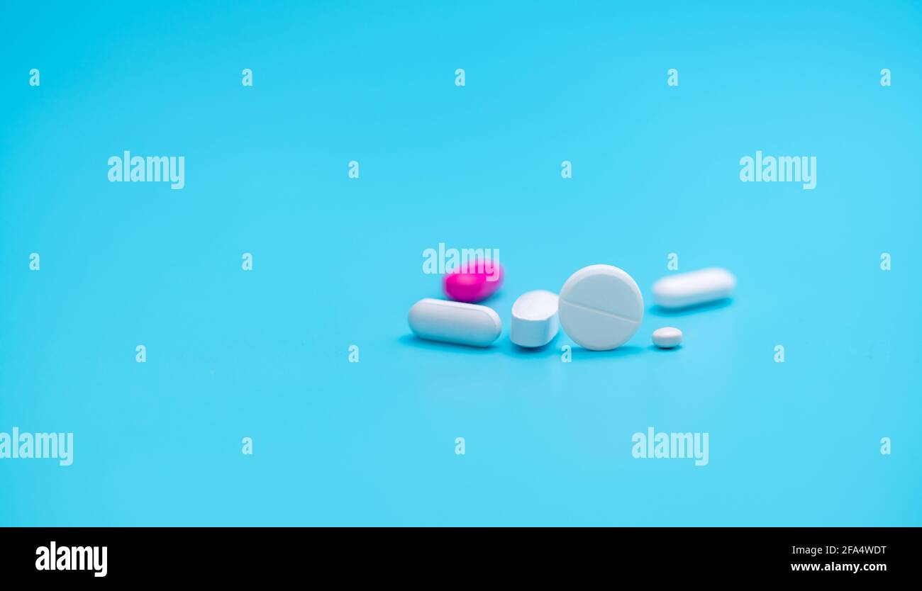 Weiße Tabletten Pillen auf Blur rosa Tablette Pille und blauen Hintergrund. Apothekenbanner. Pharmaindustrie. Strategie der Krankenversicherung. Verordnung. Stockfoto
