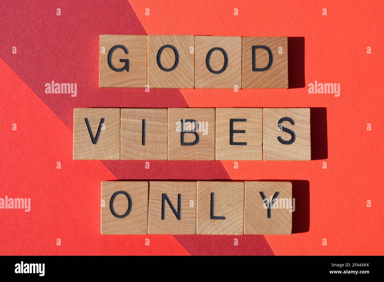 Nur gute Vibes, positive Phrase in hölzernen Buchstaben auf rotem Hintergrund isoliert Stockfoto