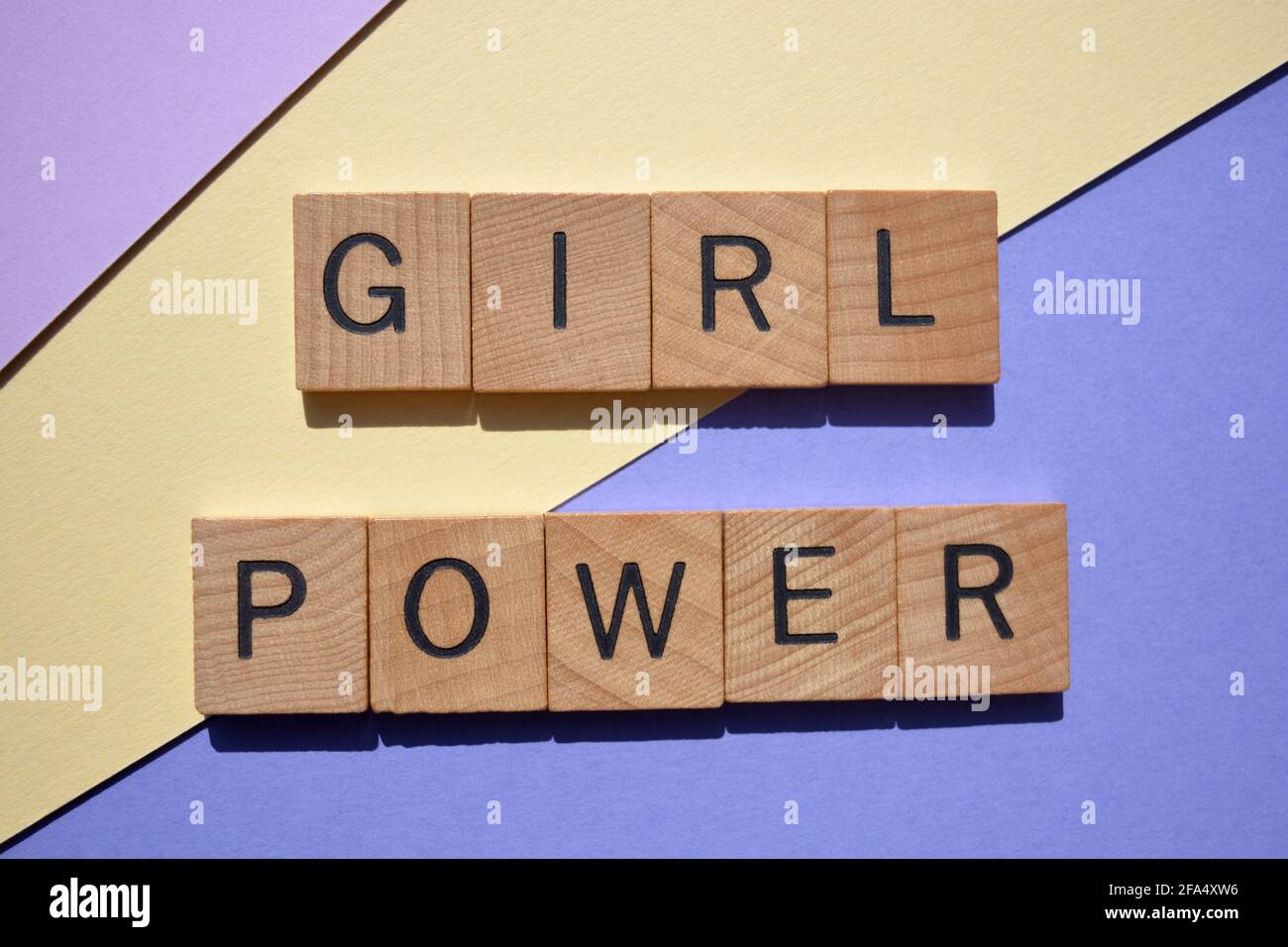Girl Power, Wörter in hölzernen Buchstaben auf buntem Hintergrund isoliert Stockfoto
