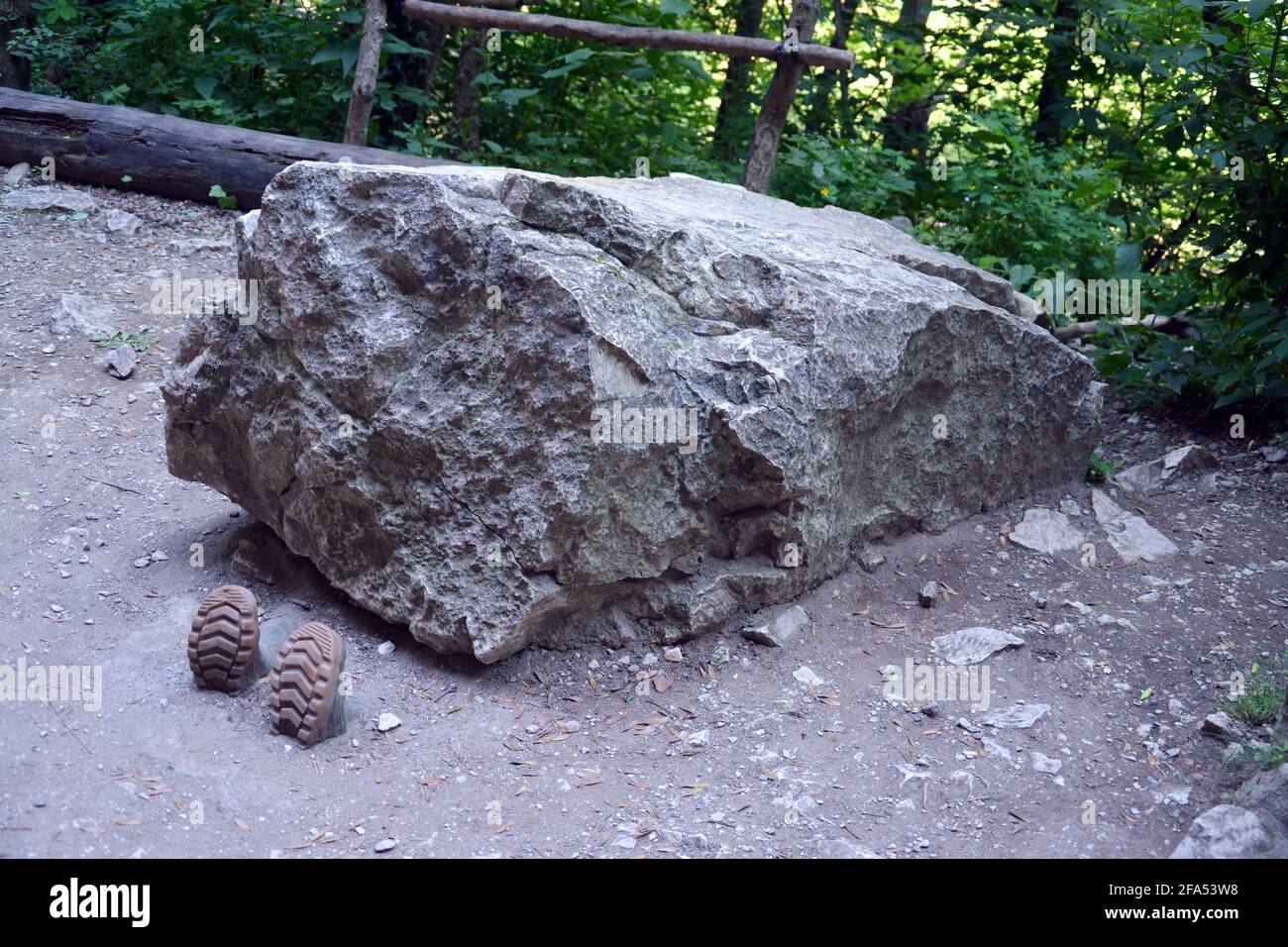 Riesiger Stein auf dem Boden mit einem Personenschuh, der in der Turda-Schlucht, Cheile Turzii, Rumänien, sichtbar ist Stockfoto