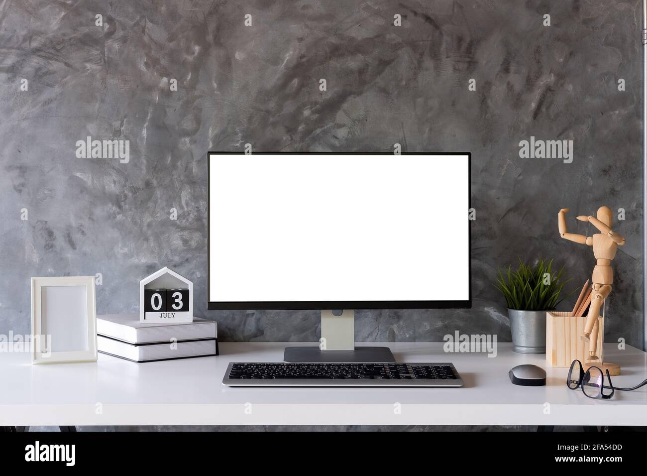 Mock Up : stilvoller oder Designer-Arbeitsplatz mit Desktop-Computer, kreatives Zubehör, Zimmerpflanzen und Vintage-Bücher auf weißem Arbeitstisch zu Hause oder im Studio Stockfoto