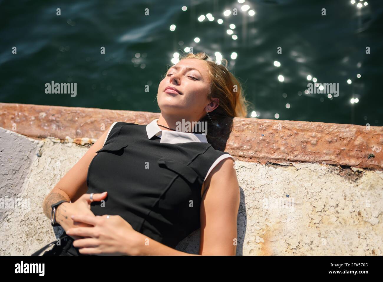 Frau in Kleid genießt Meer auf dem Pier. Stockfoto