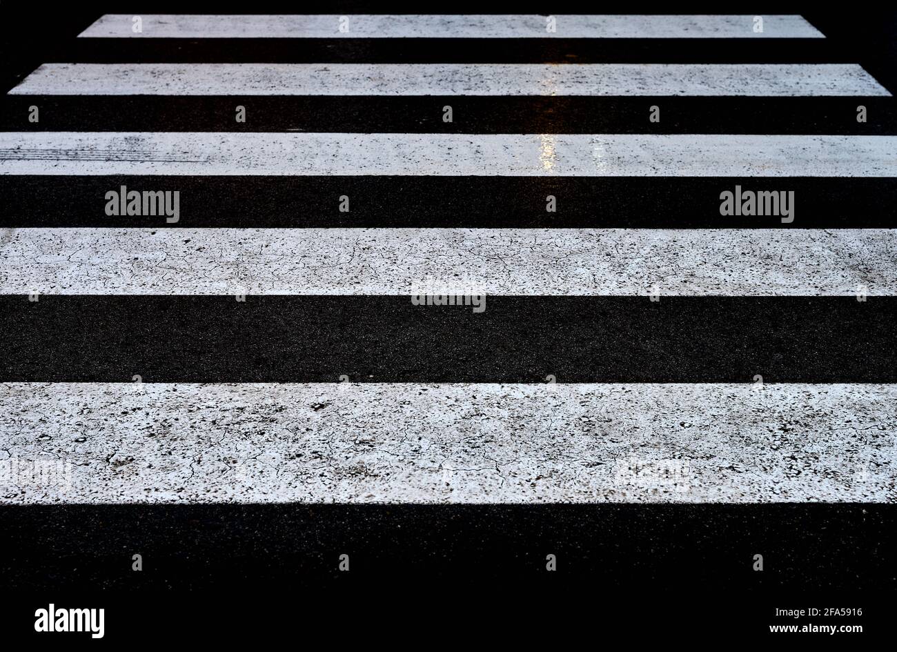 Detail einer Ansicht eines schwarz-weißen Fußgängerübergangs Im Regen Stockfoto