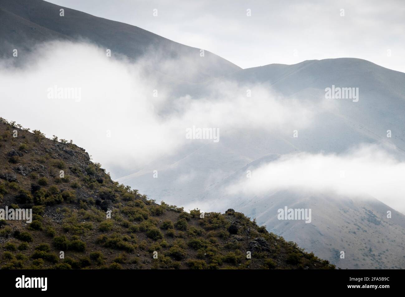 Nebel und niedrige Wolken in den Bergen über dem Lake Benmore, MacKenzie Country, South Island, Neuseeland. Stockfoto
