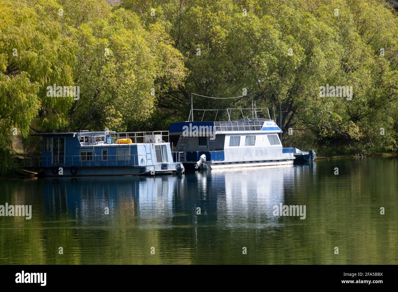 Boote und Hausboote vertäuten Segler, die auf Lake Benmore, MacKenzie Country, South Island, Neuseeland, fahren. Stockfoto