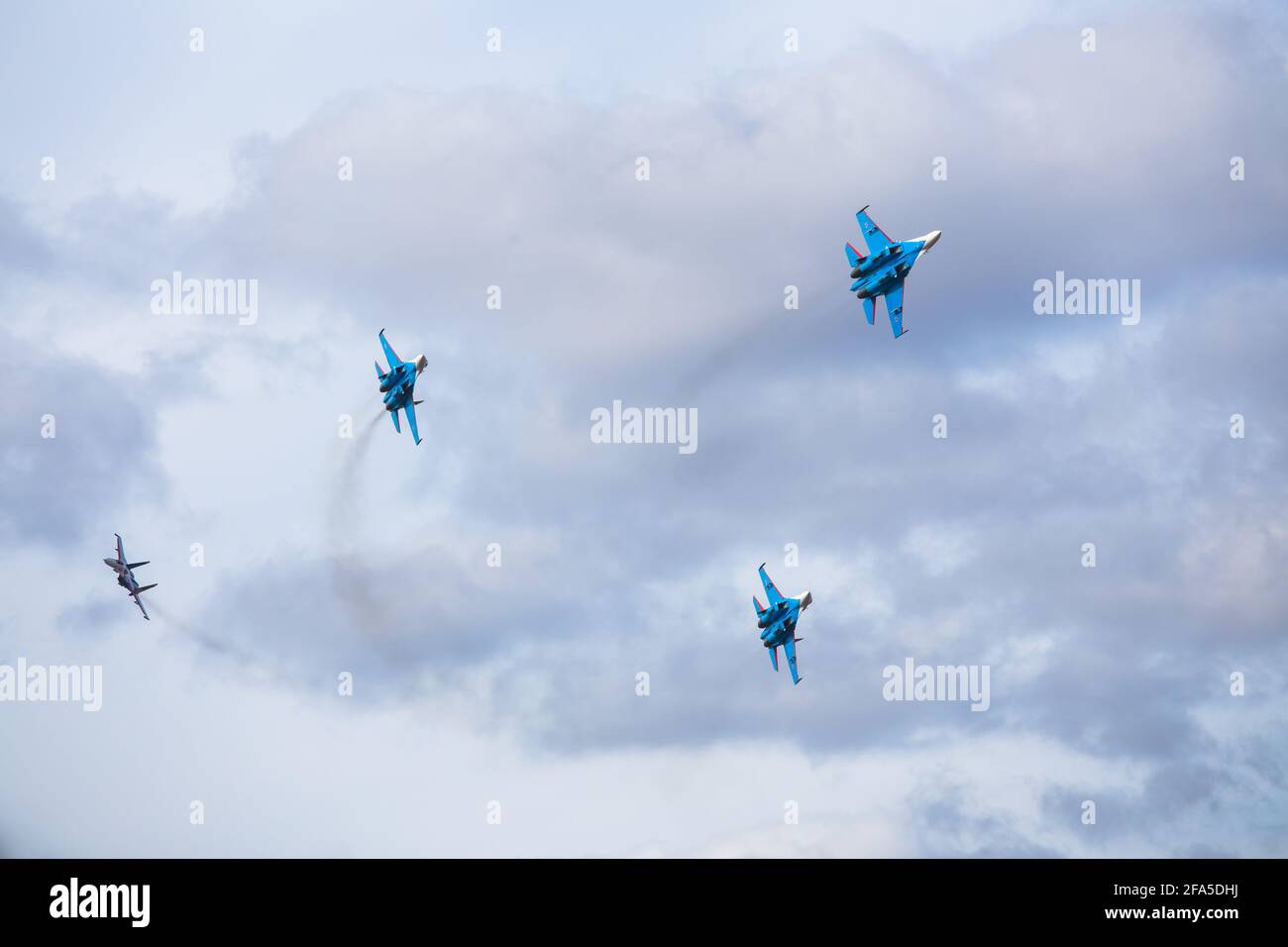 Vier Düsenflugzeuge fliegen in enger Formation. Gefährliche Kunstflüge werden auf dem Luftfahrtfestival von Piloten gezeigt. Militärparade moderner Kämpfer Stockfoto