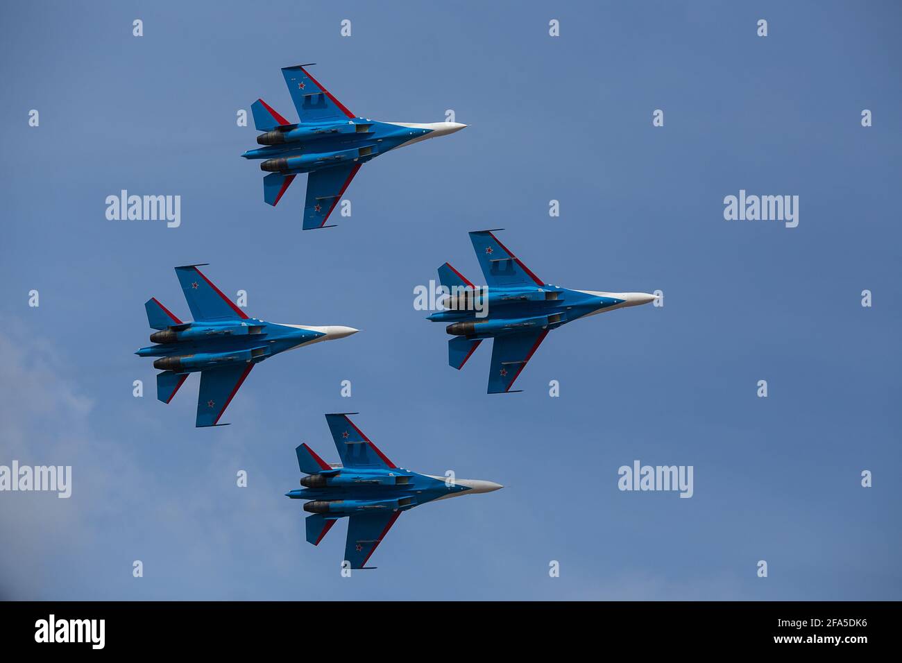 Vier Düsenflugzeuge fliegen in enger Formation. Gefährliche Kunstflüge werden auf dem Luftfahrtfestival von Piloten gezeigt. Militärparade moderner Kämpfer Stockfoto