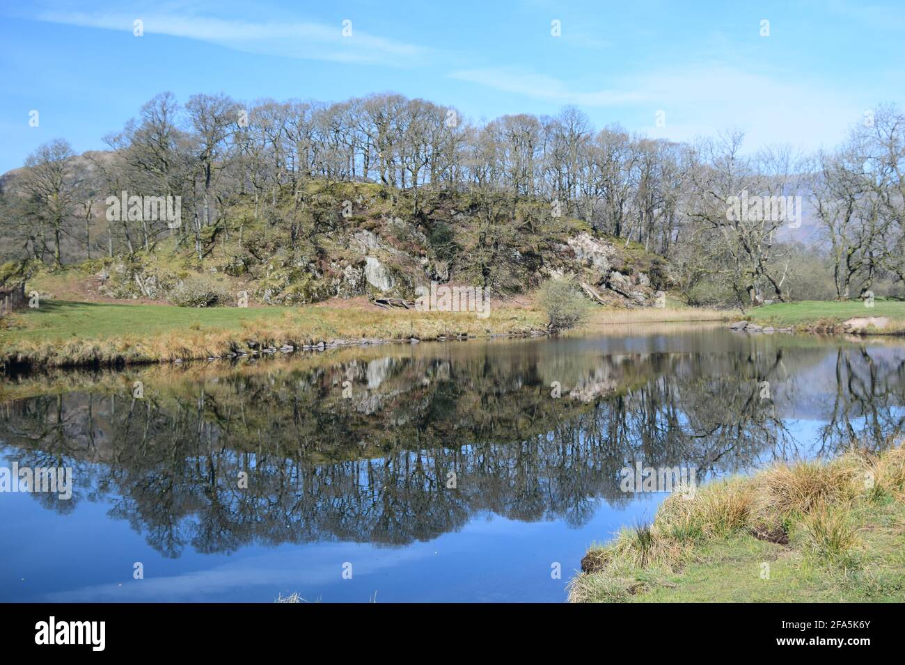 Der Bathay (breiter Fluss im alten Norden) fließt langsam von Elterwater Cumbria im Tal von Great Langdale an einem wunderschönen blauen Himmel-Tag. Stockfoto