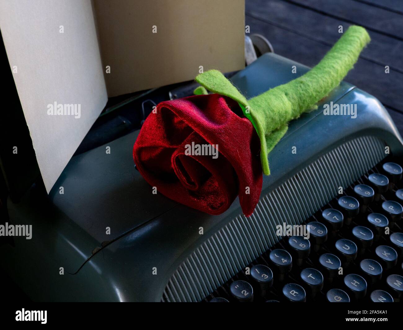 Eine Rose auf einem Stapel von Büchern und Eine Schreibmaschine Stockfoto