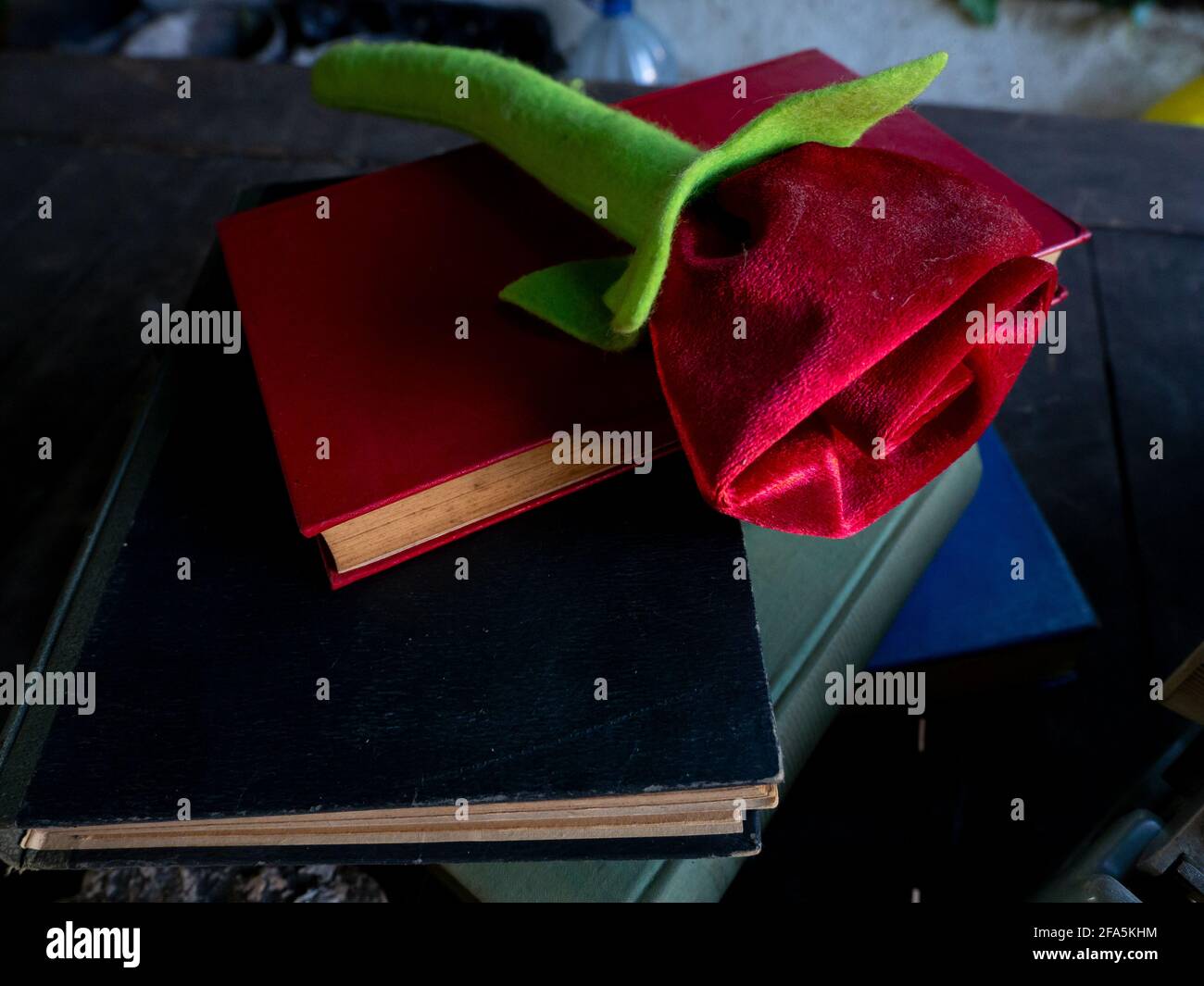 Eine Rose auf einem Stapel von Büchern und Eine Schreibmaschine Stockfoto