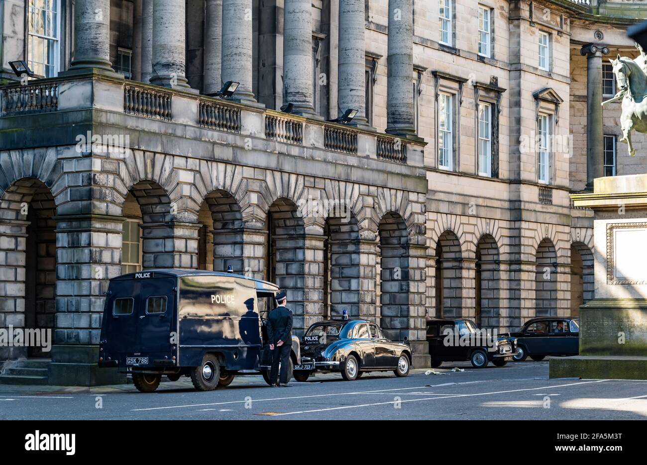 Edinburgh, Schottland, Großbritannien. 23rd April 2021. Dreharbeiten auf dem Parliament Square: Ein Drama aus der Zeit wird mit Oldtimern und Polizeifahrzeugen gedreht, die als Ein sehr britischer Skandal um die Herzogin von Argyll gedacht sind Stockfoto