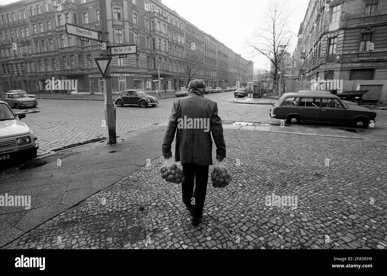 Ostberlin, DDR. 7. November 1989, nur 2 Tage vor dem Fall der Belrin-Mauer. Ein älterer Mann in Ost-Berlin mit seinen Einkaufstüten voller Kartoffeln.COPYRIGHT PHOTOGRAPH BY BRIAN HARRIS 07808-579804 Stockfoto