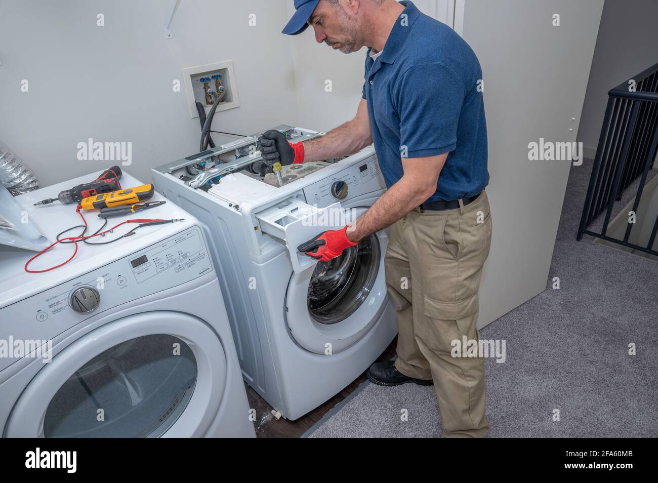 Gerätetechniker, der an einer Frontladung mit hohem Wirkungsgrad arbeitet Maschine Stockfoto