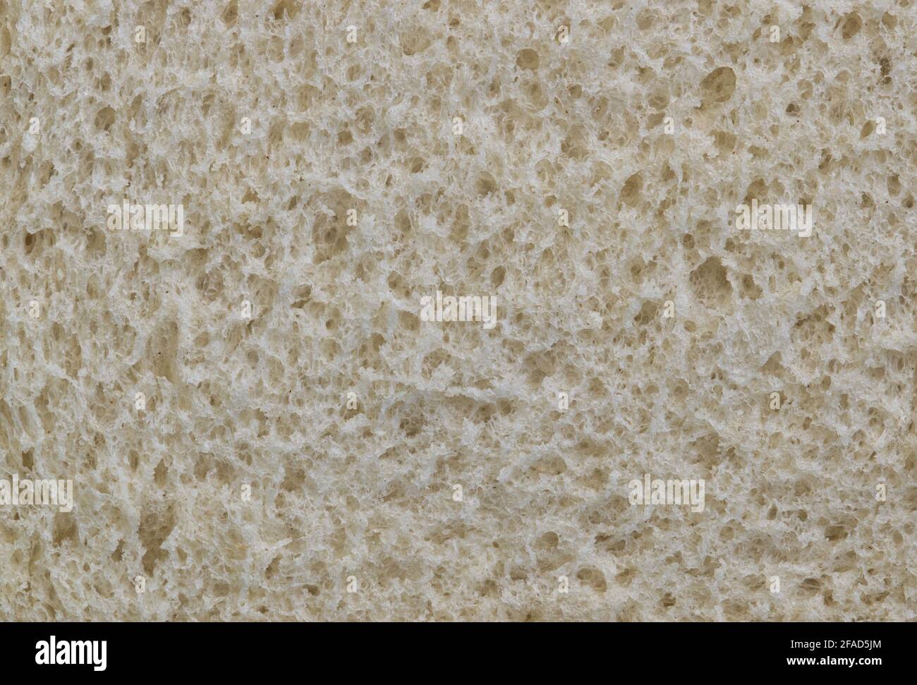 Weißbrot-Textur, Nahauflageschicht mit Makrooberflächen-Details. Eines der ältesten Grundnahrungsmittel der Menschheit. Stockfoto