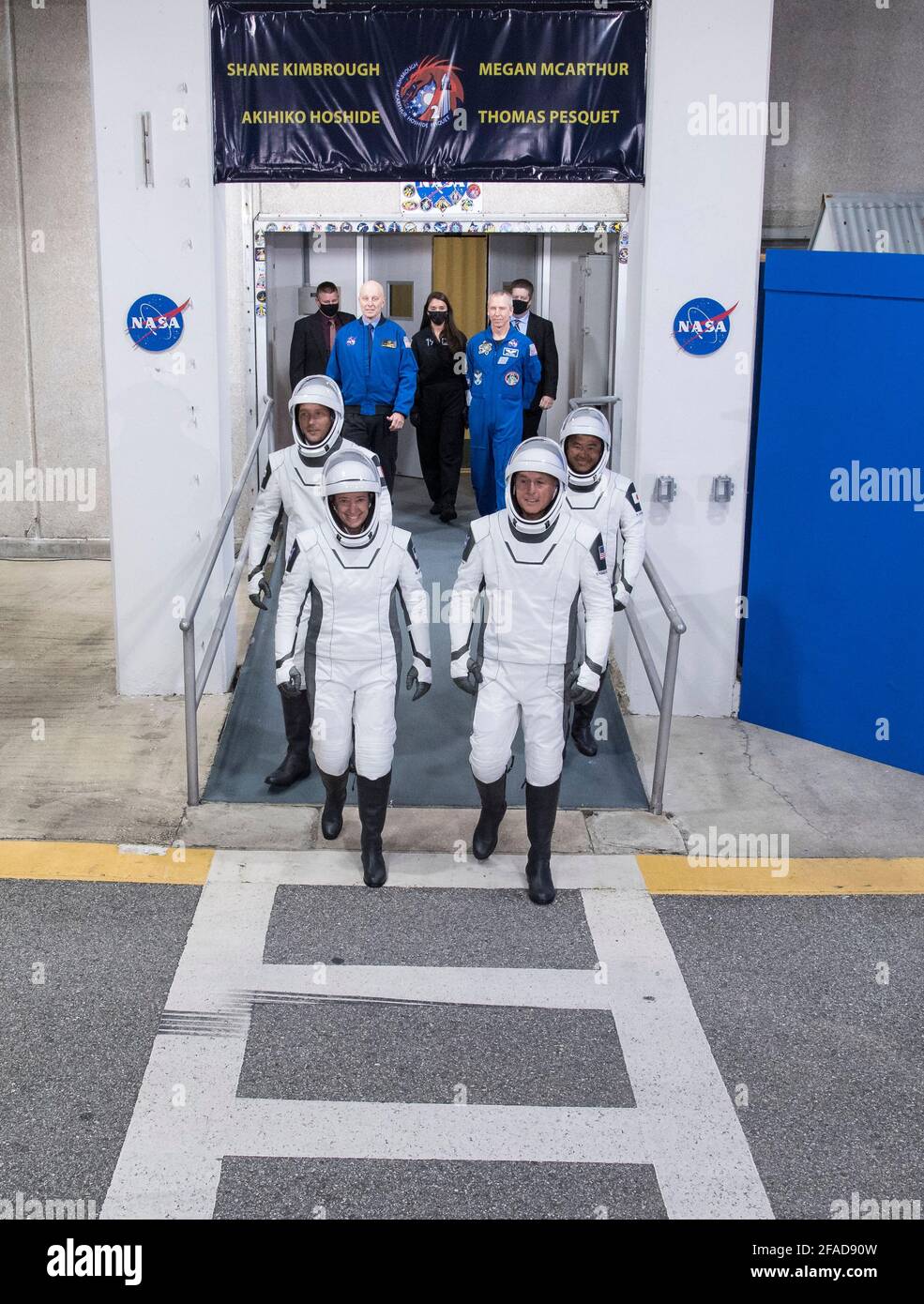 ESA-Astronaut Thomas Pesquet (Europäische Weltraumbehörde), hinten links, NASA-Astronauten Megan McArthur, vorne links, und Shane Kimbrough, vorne rechts, und Astronaut Akihiko Hoshide der Japan Aerospace Exploration Agency (JAXA), hinten rechts, mit SpaceX-Raumanzügen, Werden gesehen, wie sie sich darauf vorbereiten, das Neil A. Armstrong Operations and Checkout Building für den Launch Complex 39A zu verlassen, um die Raumsonde SpaceX Crew Dragon für den Start der Crew-2-Mission am Freitag, den 23. April 2021, im Kennedy Space Center der NASA in Florida zu besteigen. Die NASA-Mission SpaceX Crew-2 ist die zweite Crew-Rotation-Mission des SpaceX Crew Dragon Stockfoto