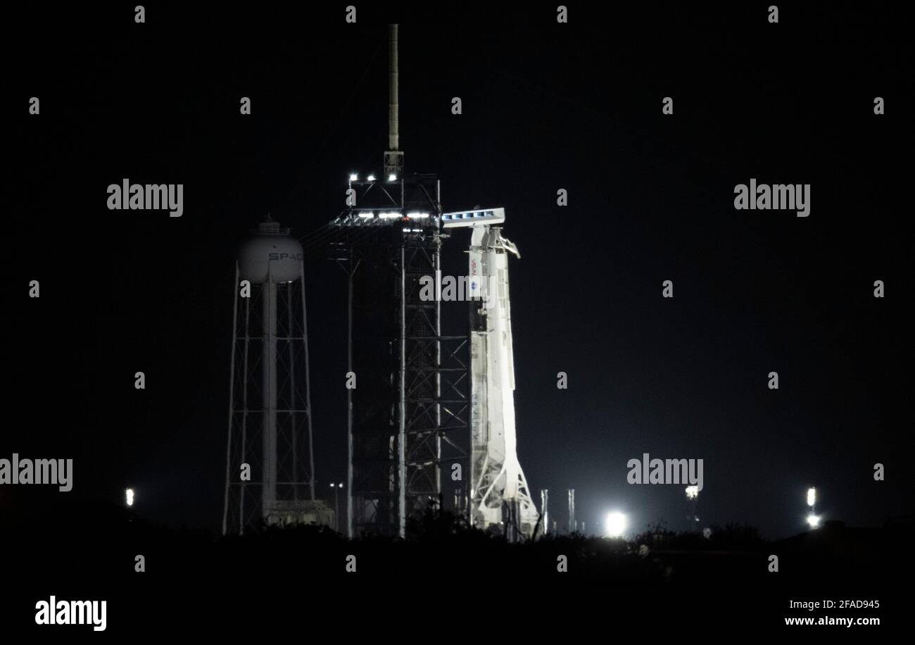 Eine SpaceX Falcon 9-Rakete mit der Crew Dragon-Sonde des Unternehmens an Bord wird von Scheinwerfern auf der Startfläche des Launch Complex 39A beleuchtet, während der Countdown für den Start der Crew-2-Mission am Freitag, den 23. April 2021, im Kennedy Space Center der NASA in Florida fortgesetzt wird. Die NASA-Mission SpaceX Crew-2 ist die zweite Rundungsmission der Raumsonde SpaceX Crew Dragon und der Falcon 9-Rakete zur Internationalen Raumstation im Rahmen des Commercial Crew Program der Agentur. Die NASA-Astronauten Shane Kimbrough und Megan McArthur, der ESA-Astronaut Thomas Pesquet und Jap Stockfoto