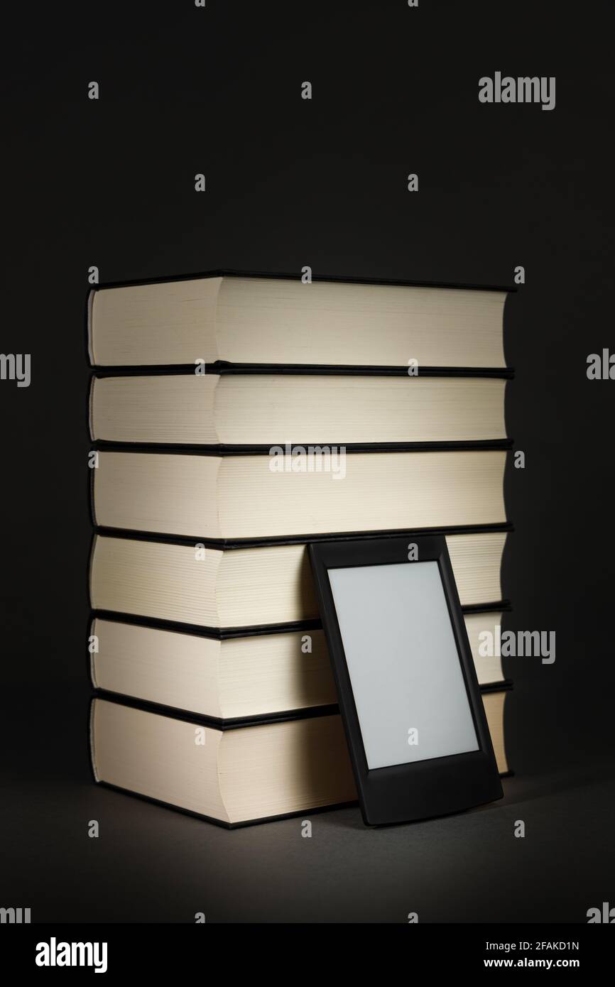 Modernes E-Book neben einem Haufen alter Bücher Stockfoto
