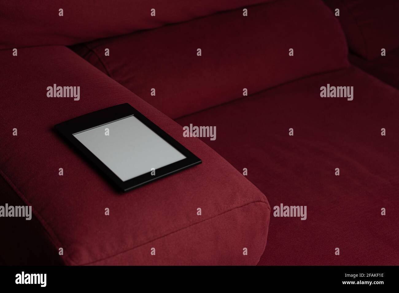 Modernes E-Book auf einem roten Sofa Stockfoto