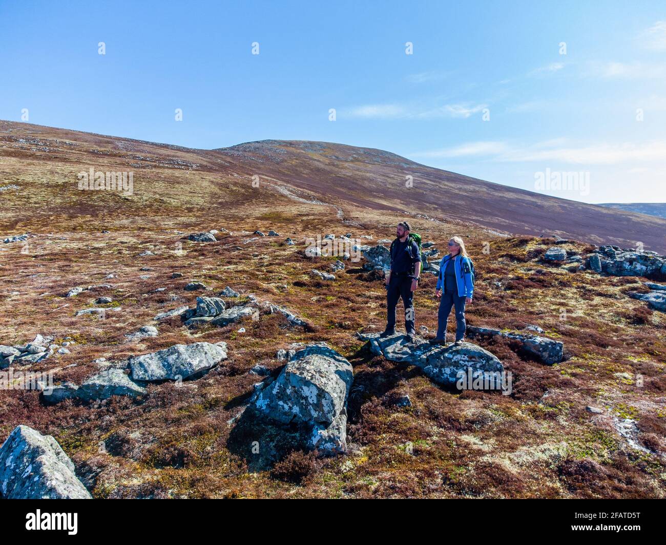 Zwei Wanderer auf dem Weg hinauf zum Meall Chuaich, einem Munro-Berg in der Nähe von Dalwhinnie, Schottland. Der Gipfel ist im Hintergrund sichtbar Stockfoto