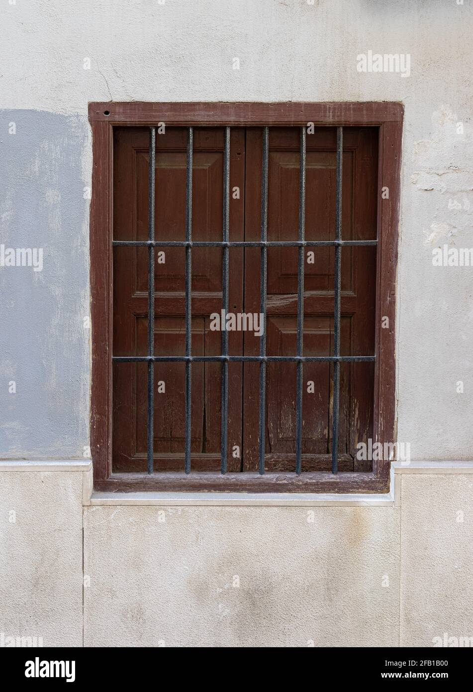 Vintage-Fenster mit Eisengitter an einer Steinwand. Valencia, Spanien Stockfoto