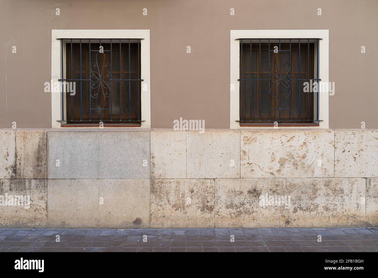 Zwei Vintage-Fenster mit Eisengitter an einer Steinwand. Valencia, Spanien Stockfoto