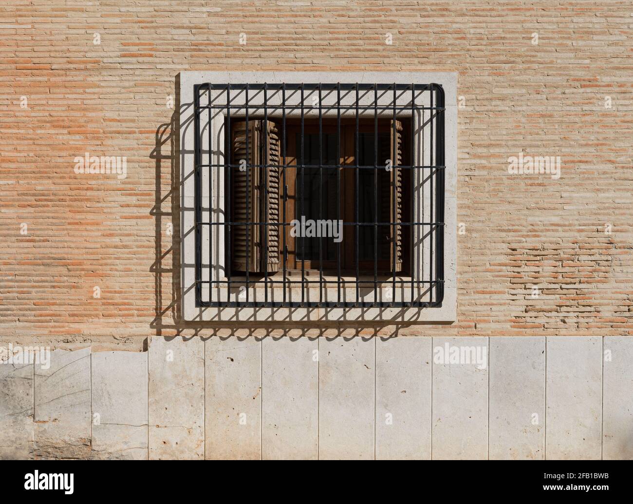 Vintage-Fenster mit Eisengitter an einer Ziegelwand. Valencia, Spanien Stockfoto