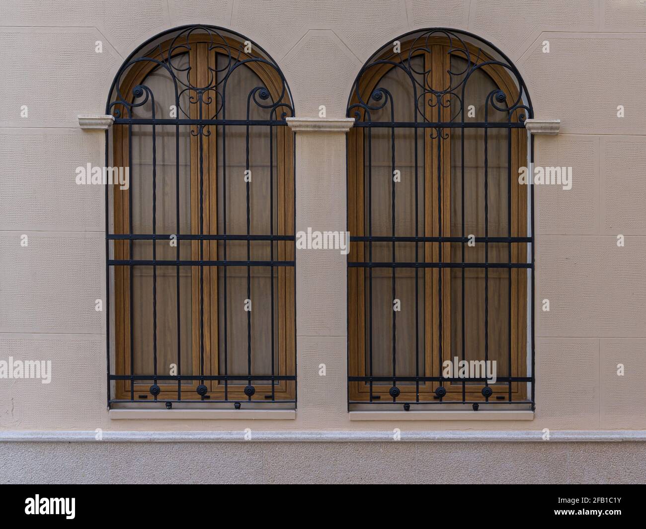 Zwei Vintage-Fenster mit Eisengitter an einer Steinwand. Valencia, Spanien Stockfoto