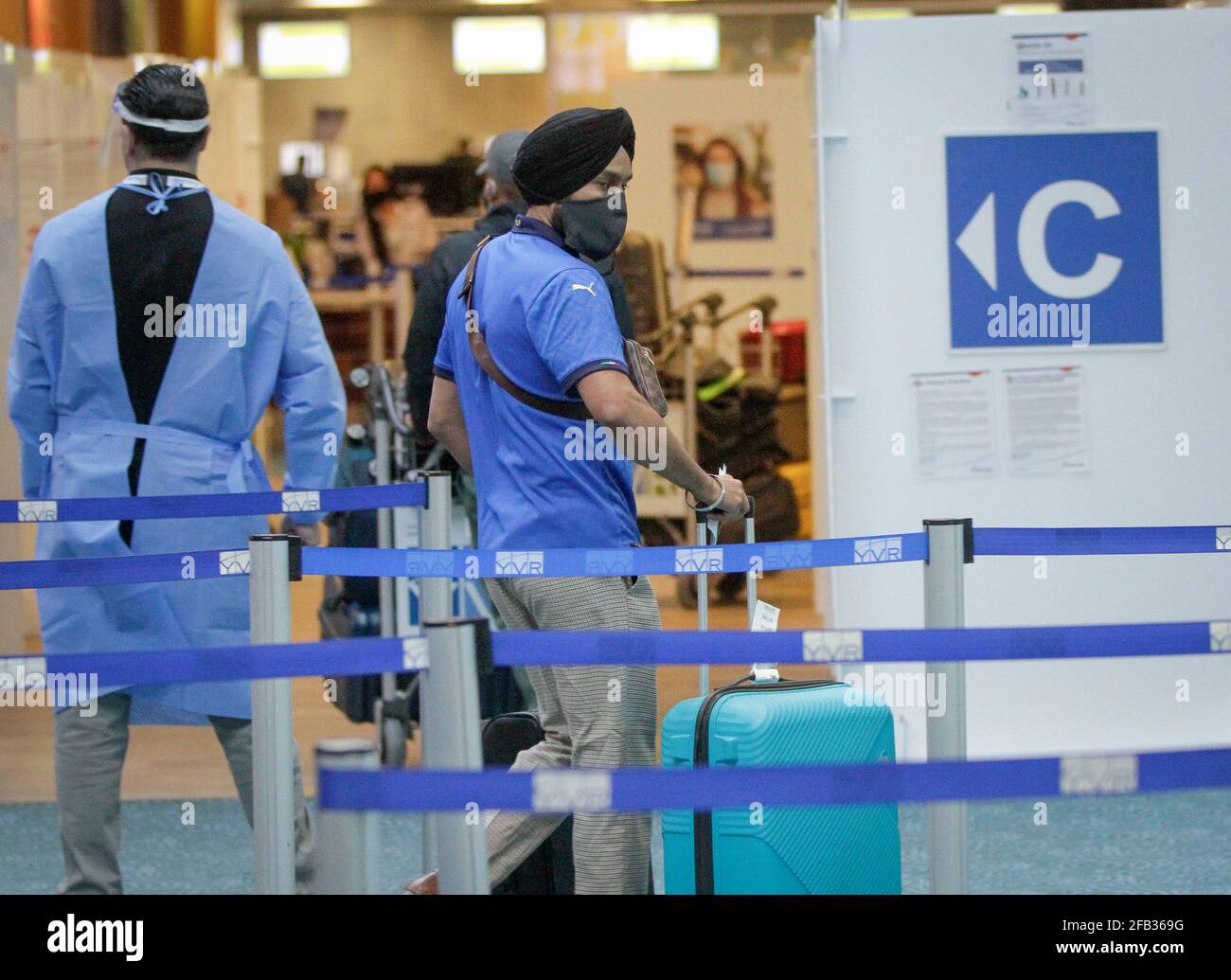 Richmond, Kanada. April 2021. Ein Passagier aus Indien wartet in der Ankunftshalle des Vancouver International Airport in Richmond, British Columbia, Kanada, am 23. April 2021 auf den COVID-19-Test. Kanada kündigte am Donnerstag ein 30-tägiges Verbot aller Flüge von Indien und Pakistan an, da die COVID-19-Fälle in den beiden Ländern weiter ansteigenden. Quelle: Liang Sen/Xinhua/Alamy Live News Stockfoto