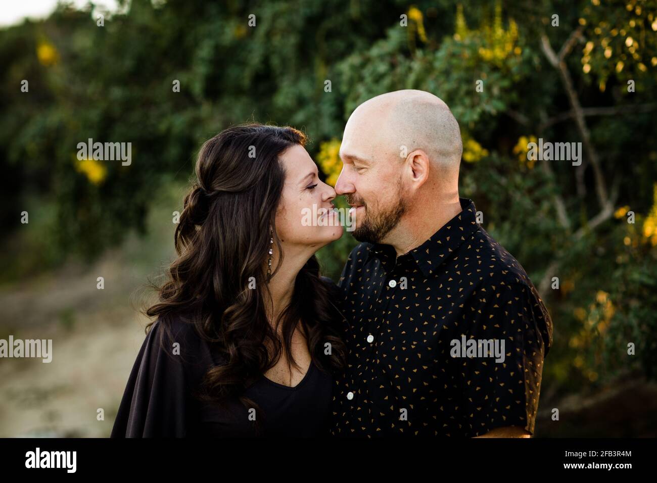 Ehemann und Ehefrau kuscheln im Garten in San Diego Stockfoto