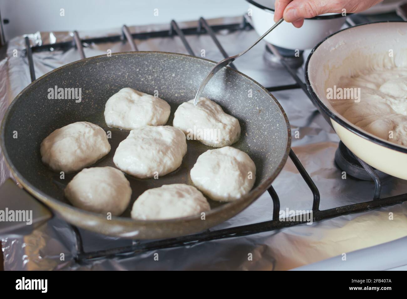 Hefepfannkuchen werden in Öl in einer Pfanne gebraten Herd Stockfoto