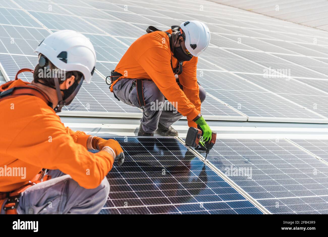 Nicht erkennbare Solarpanel-Techniker arbeiten in der spanischen Fabrik zusammen Stockfoto