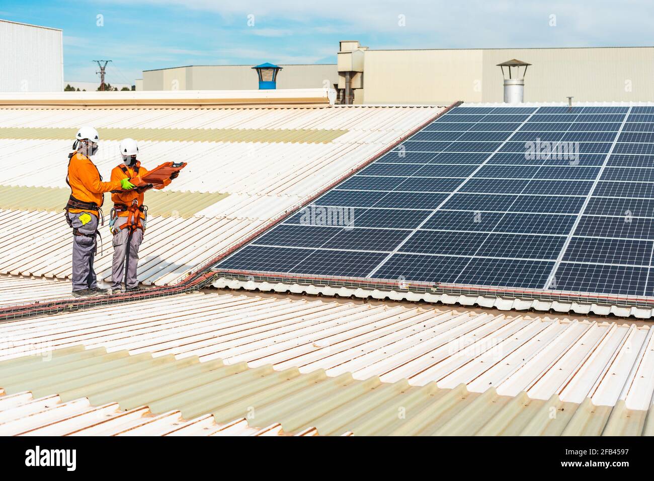 Nicht erkennbare Solarpanel-Techniker arbeiten in der spanischen Fabrik zusammen Stockfoto