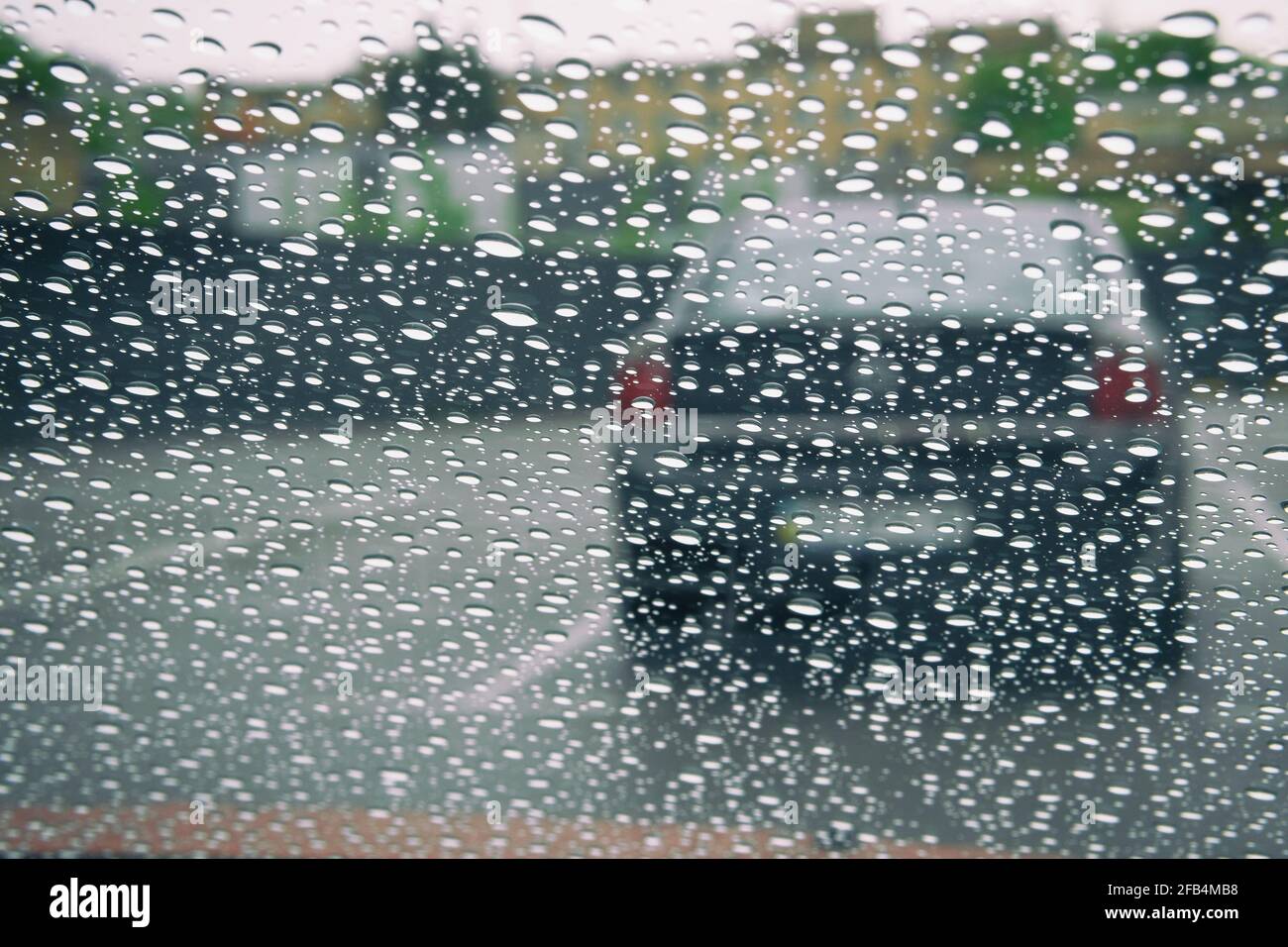 Herbstregen auf dem Autoglas, selektiver Fokus auf Regentropfen. Wassertropfen auf dem Fenster. Stockfoto