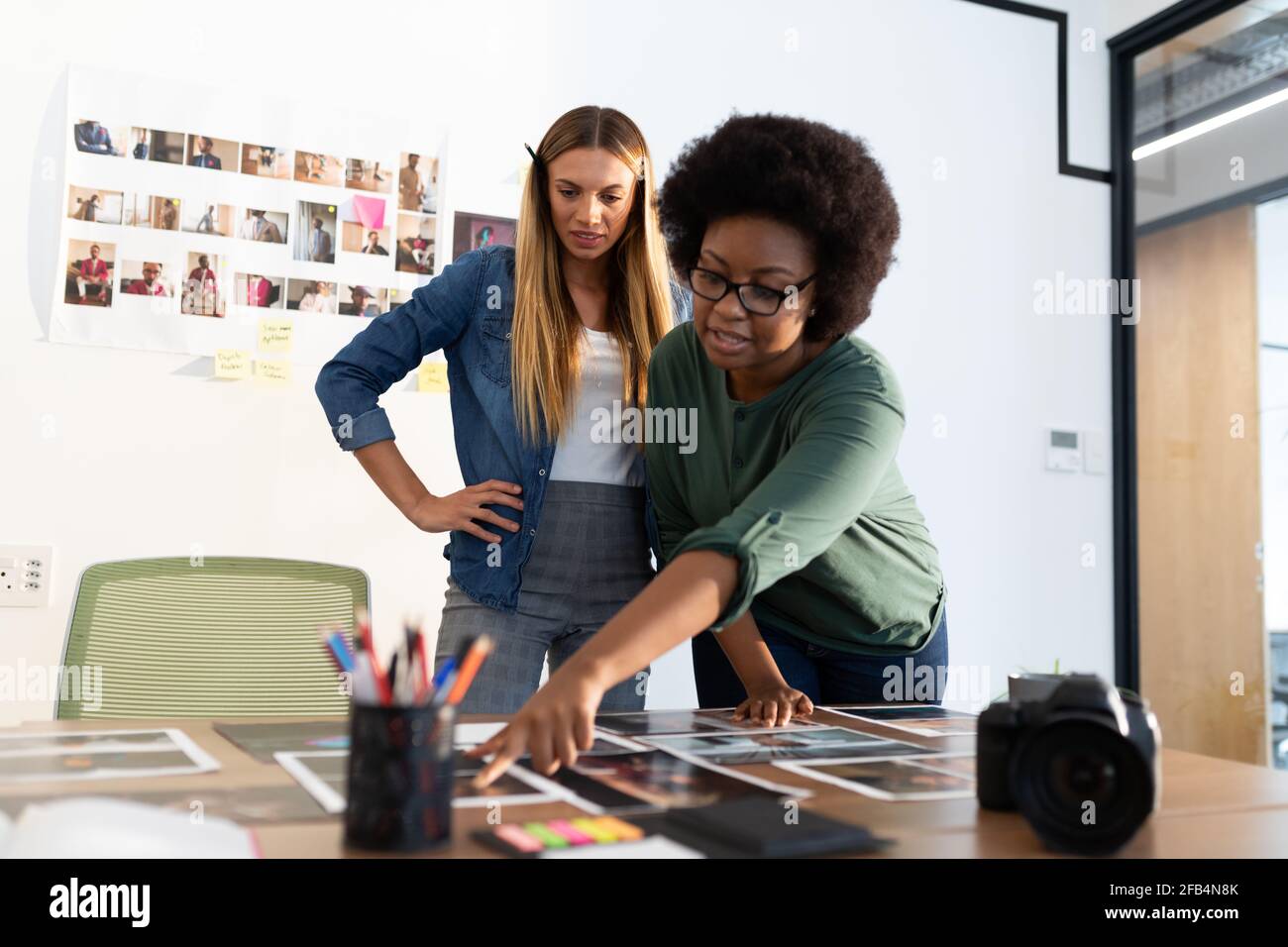 Verschiedene weibliche Geschäftskollegen Brainstorming zeigen auf Fotos in der Sitzung Zimmer Stockfoto