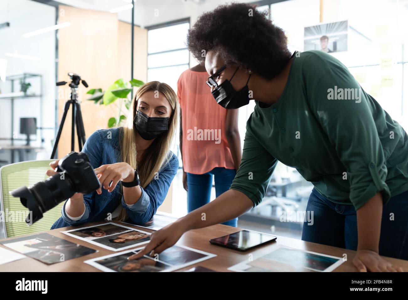 Verschiedene Gruppe von Geschäftskollegen tragen Masken Brainstorming Blick auf Fotos im Tagungsraum Stockfoto