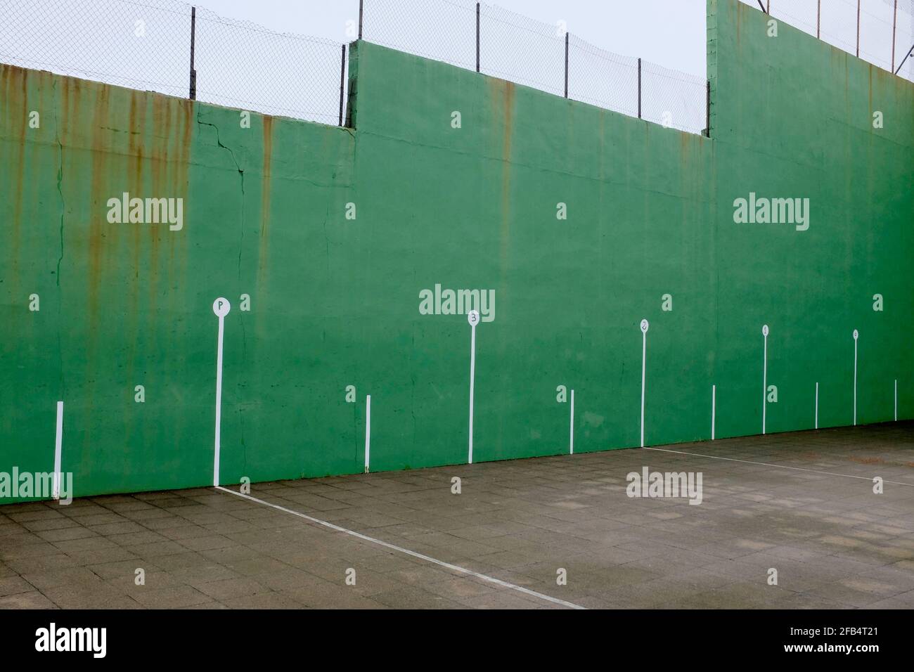 Grüner Sportplatz mit einer Mauer Stockfoto