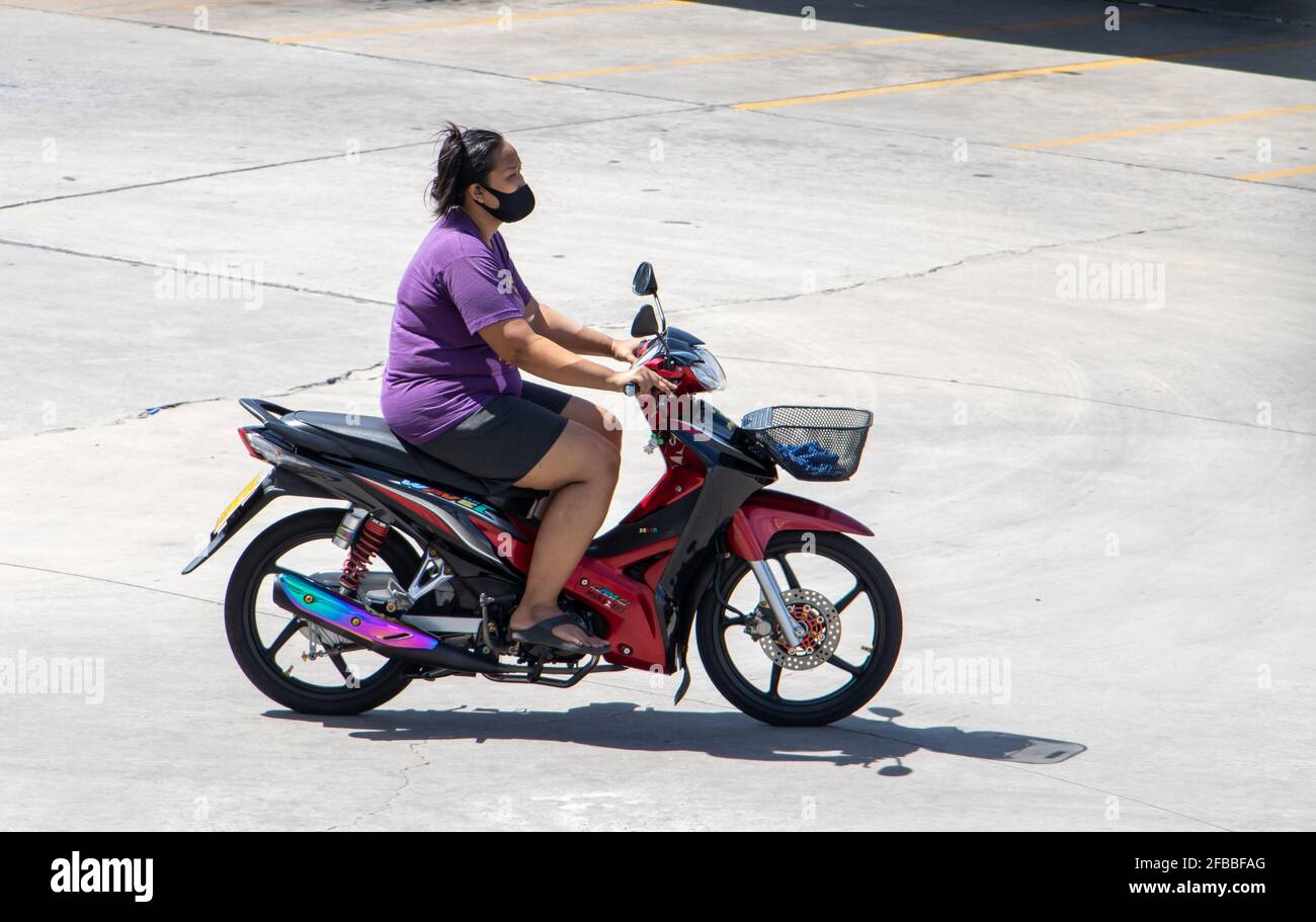 SAMUT PRAKAN, THAILAND, JULI 09 2020, Frau mit Gesichtsmaske fährt ein Motorrad Stockfoto