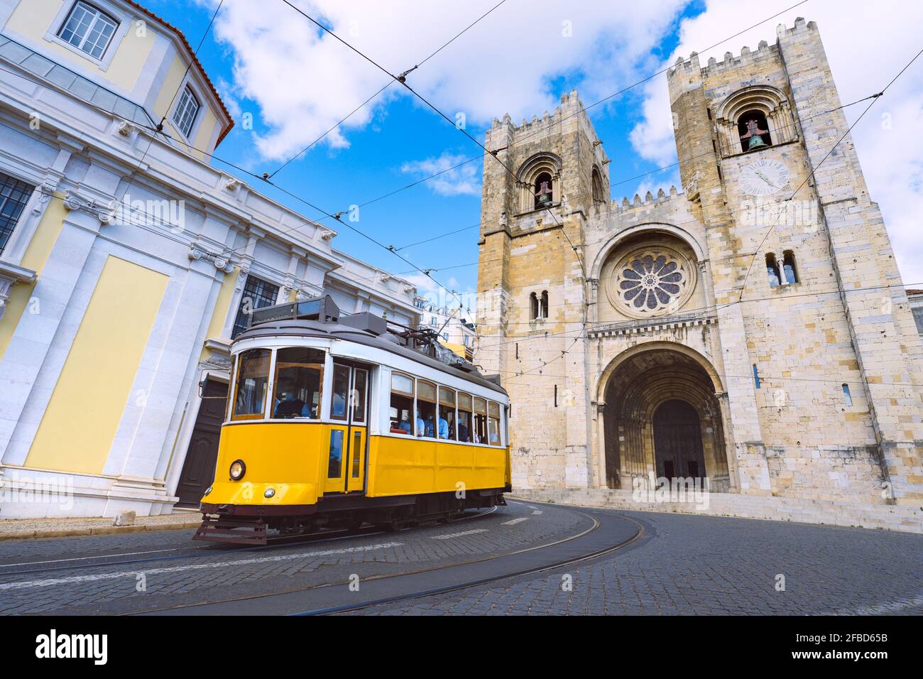 Lissabon-Stadt und berühmte gelbe Straßenbahn 28 vor Kathedrale Santa Maria Stockfoto