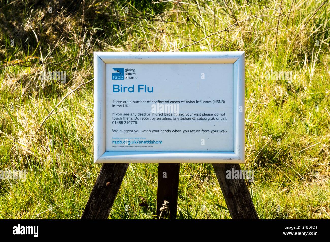 Ein Hinweis auf das RSPB-Reservat von Snettisham warnt die Menschen vor den Anzeichen einer Vogelgrippe. Stockfoto