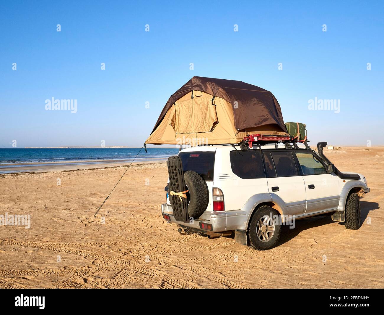 Zelt auf dem Dach eines geparkten Geländewagens aufgestellt Am Sandstrand Stockfoto