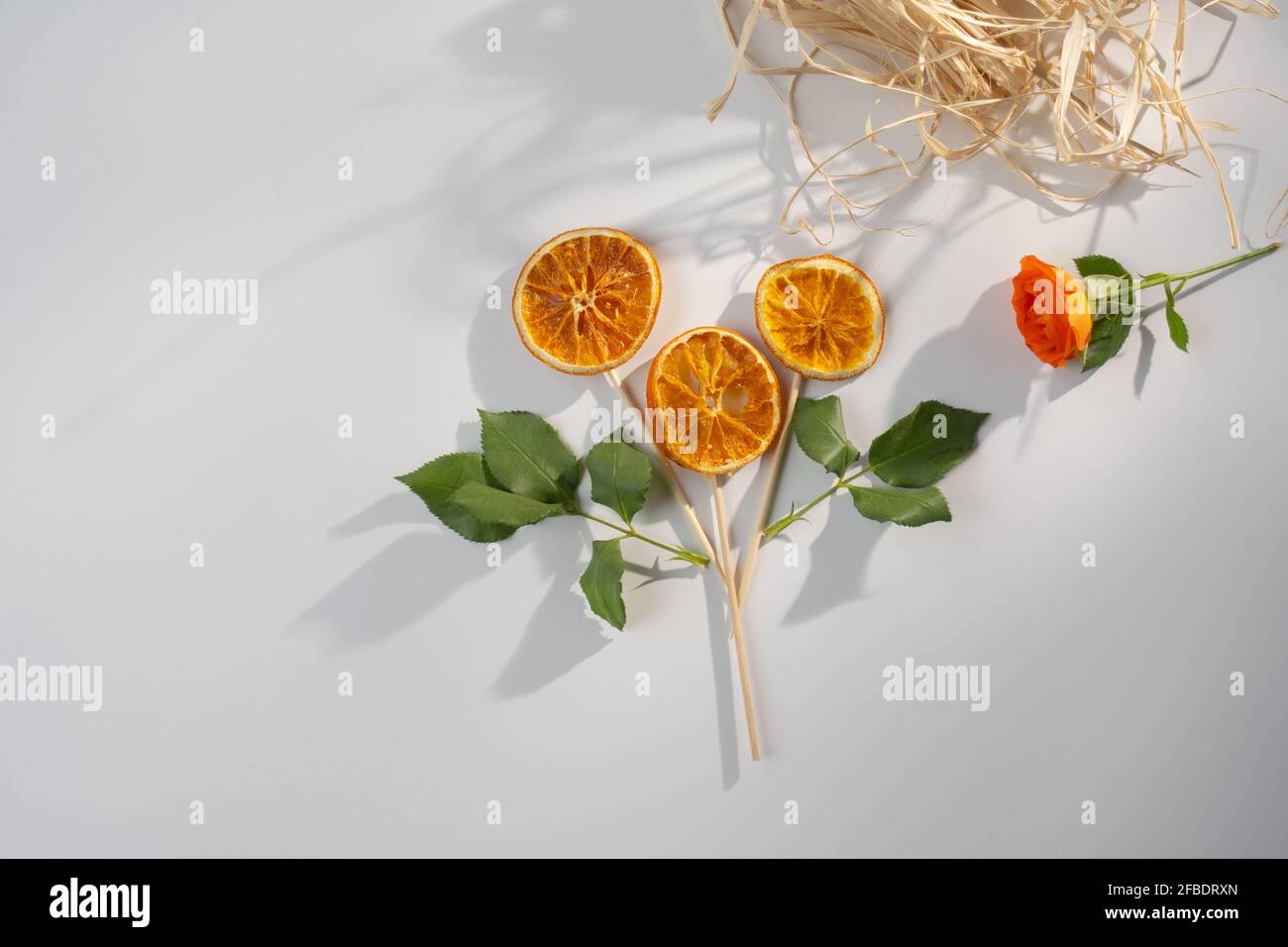 Blume aus getrockneten orangefarbenen Scheiben auf weißem Hintergrund mit schönen Schatten und Kopierraum, Grußkartenkonzept Stockfoto