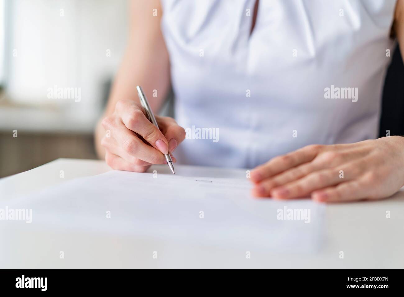 Geschäftsfrau unterzeichnet Vertrag im Büro Stockfoto